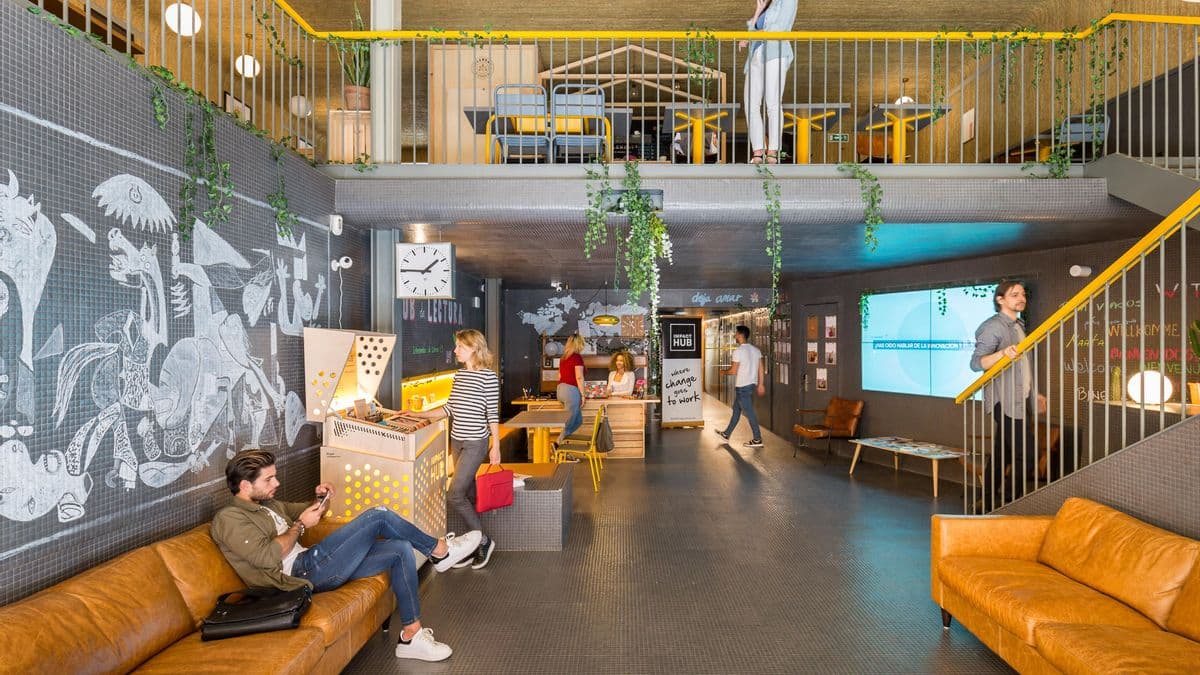 Espacio de coworking en Impact Hub Madrid con profesionales trabajando