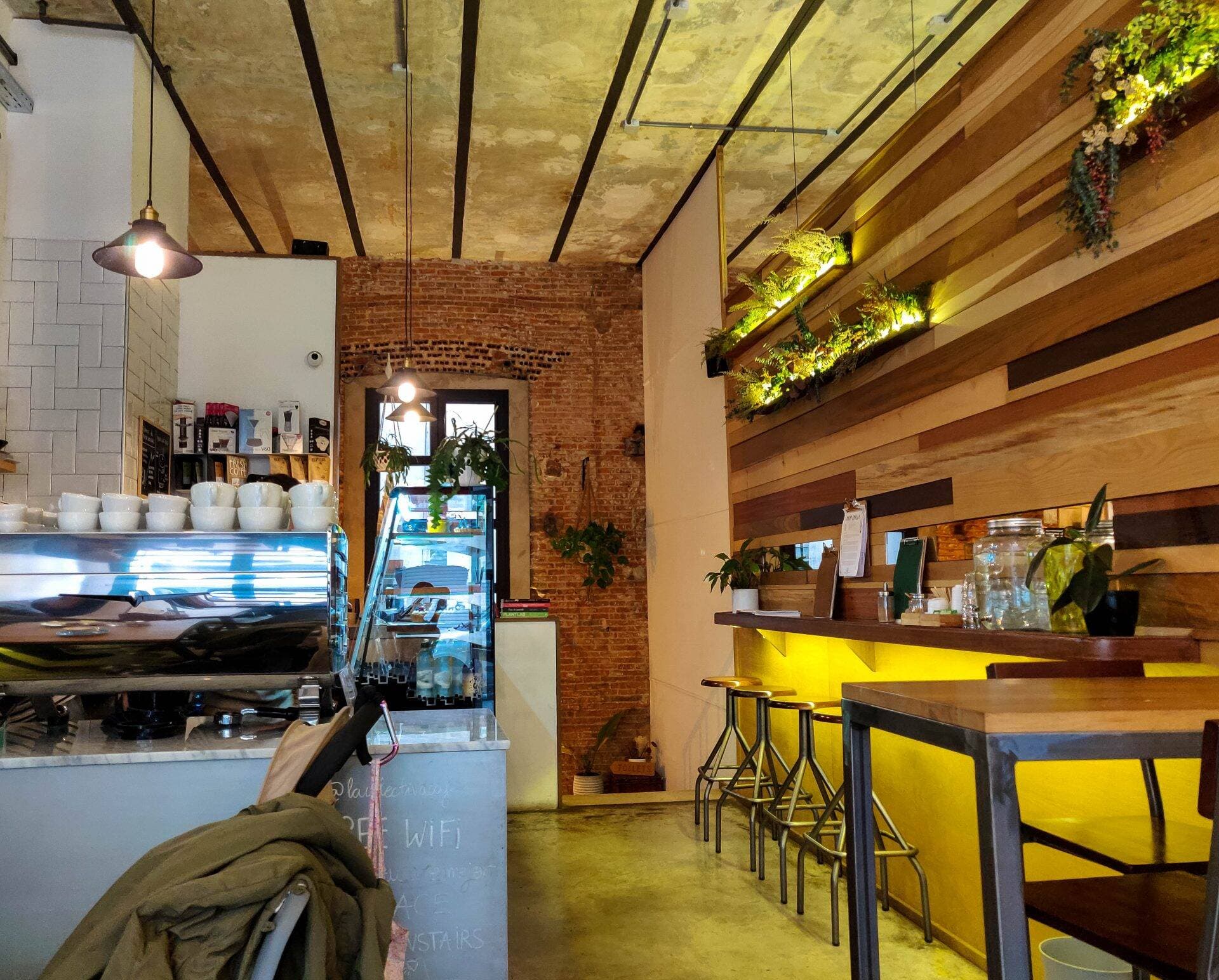 Ambiente acogedor en La Colectiva Café con mesas y repostería vegana