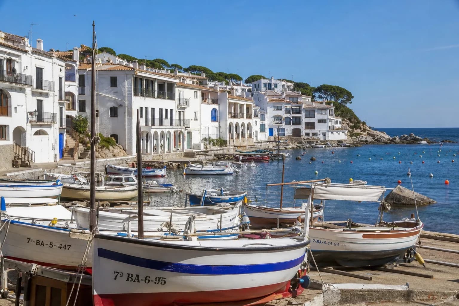 Puerto pesquero de pueblo costero español con barcos y casas de colores
