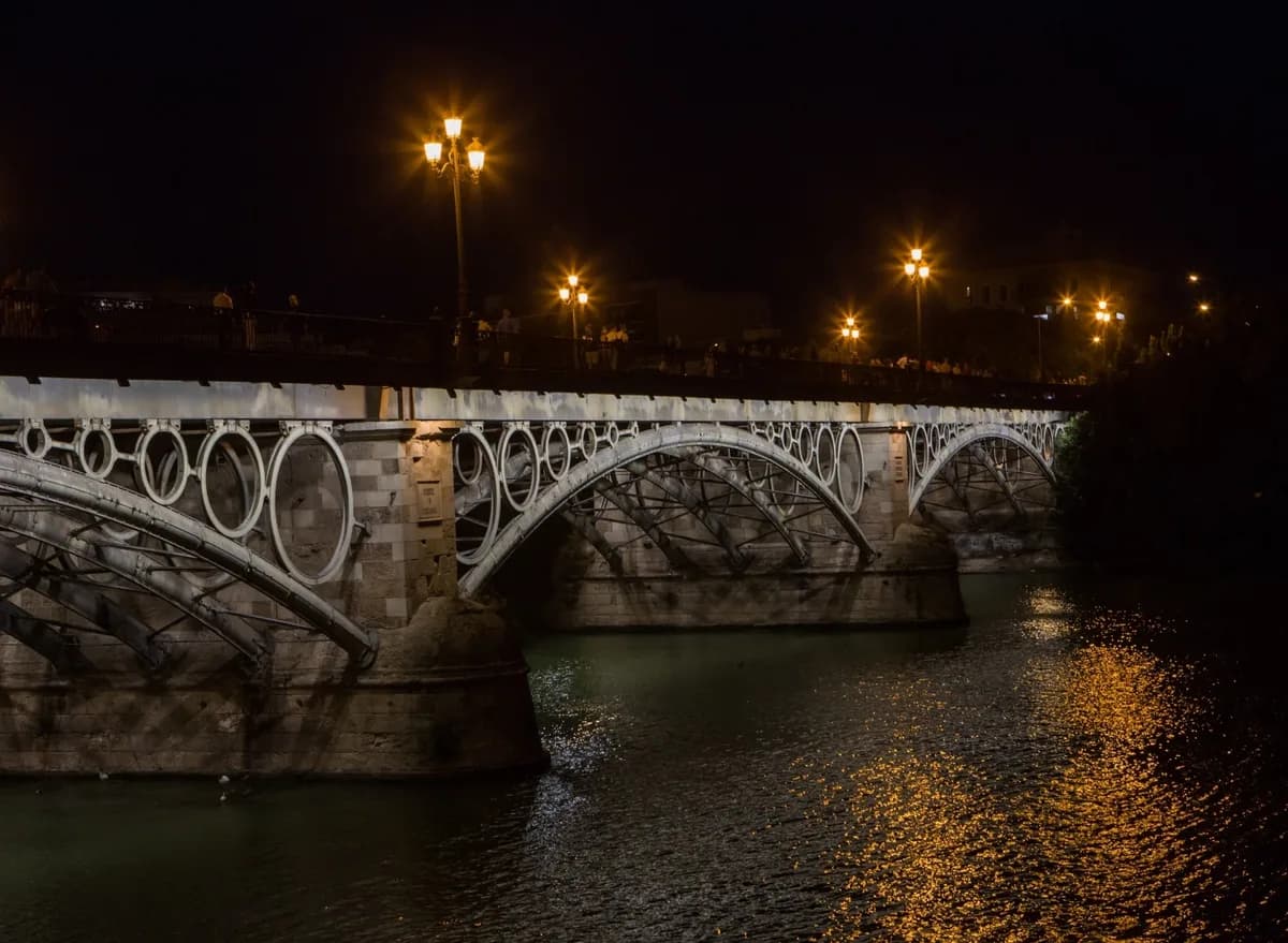 Puente de Triana iluminado sobre Guadalquivir