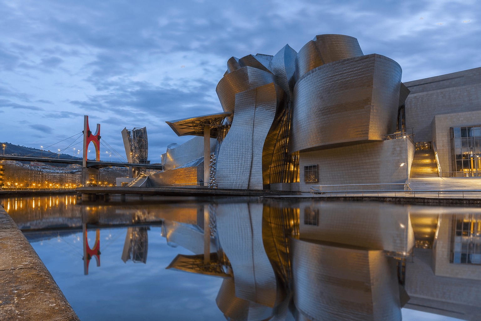 Museo Guggenheim Bilbao reflejado en la ría al atardecer